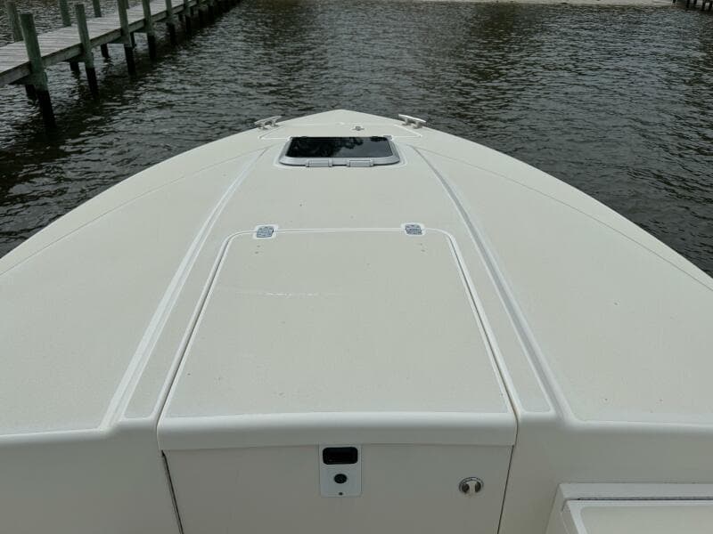 2004 Intrepid 32 Cuddy boat bow view on water near dock.