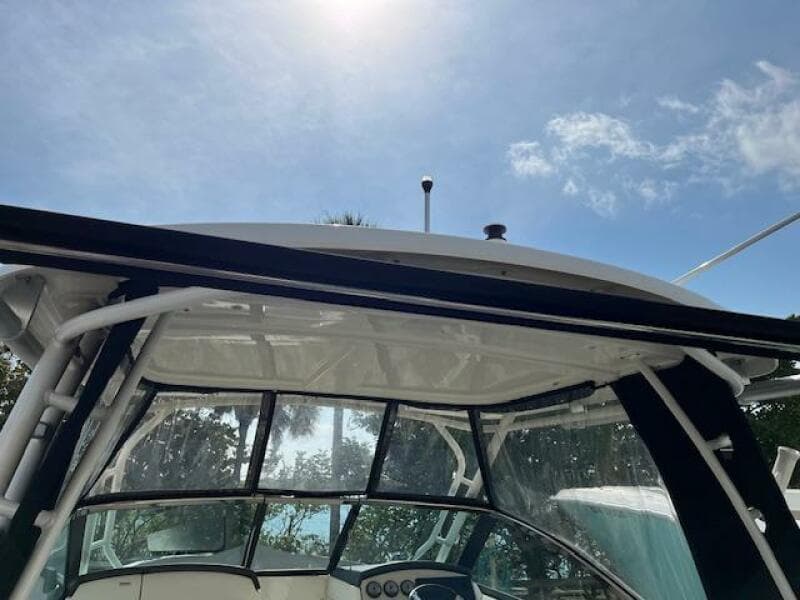 2018 Boston Whaler 270 Vantage boat with clear canopy under sunny sky.