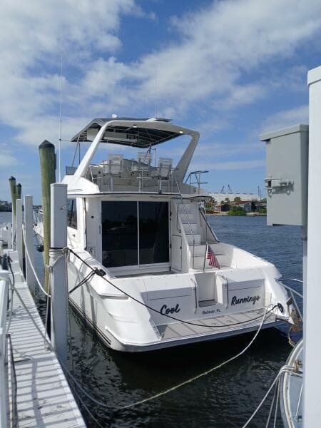 1997 Sea Ray 550 Sedan Bridge yacht docked at marina under blue sky.