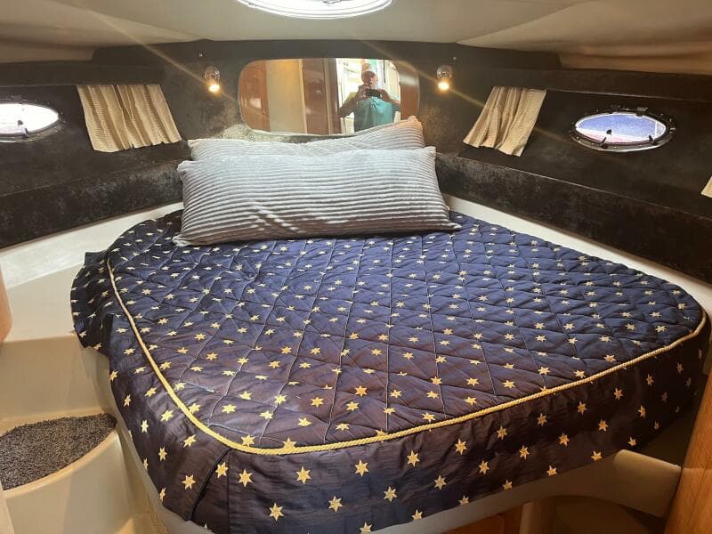 2003 Regal Commodore 3860 cabin interior with cozy bed and star-patterned quilt.