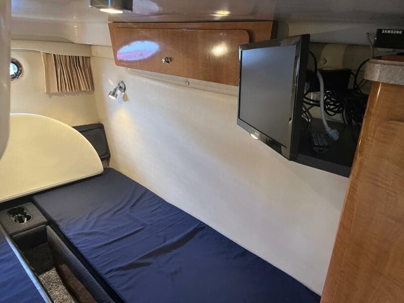 Interior cabin of 2003 Regal Commodore 3860 with bed, TV, and storage.