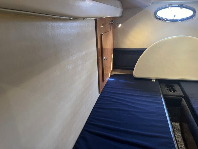 Interior cabin of a 2003 Regal Commodore 3860 yacht with blue bedding.