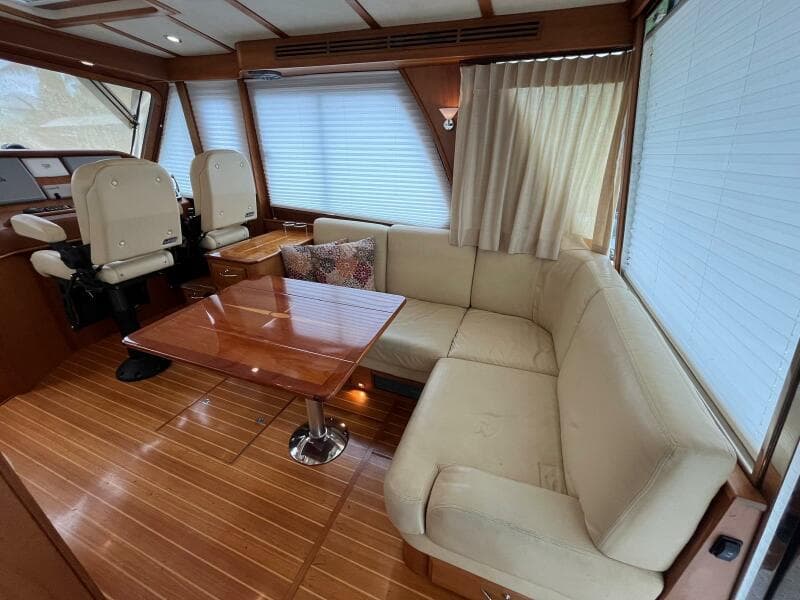 Interior of 2013 Sabre 48 Salon Express with beige seating and wooden table.