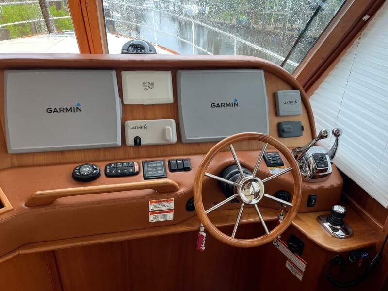 2013 Sabre 48 Salon Express helm with Garmin navigation displays and classic wooden steering wheel.