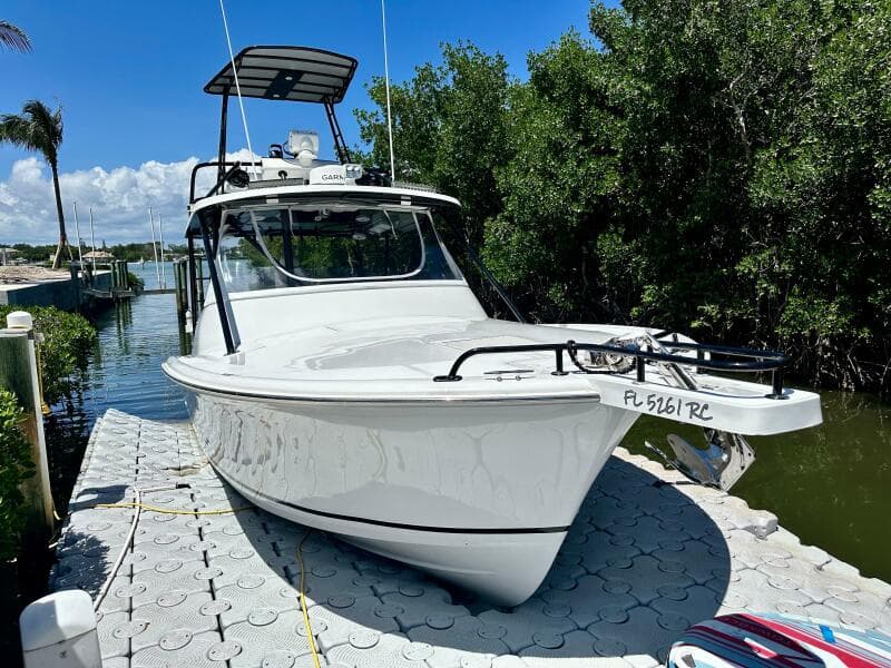 2000 Luhrs Tournament 320 Open boat docked near lush greenery.