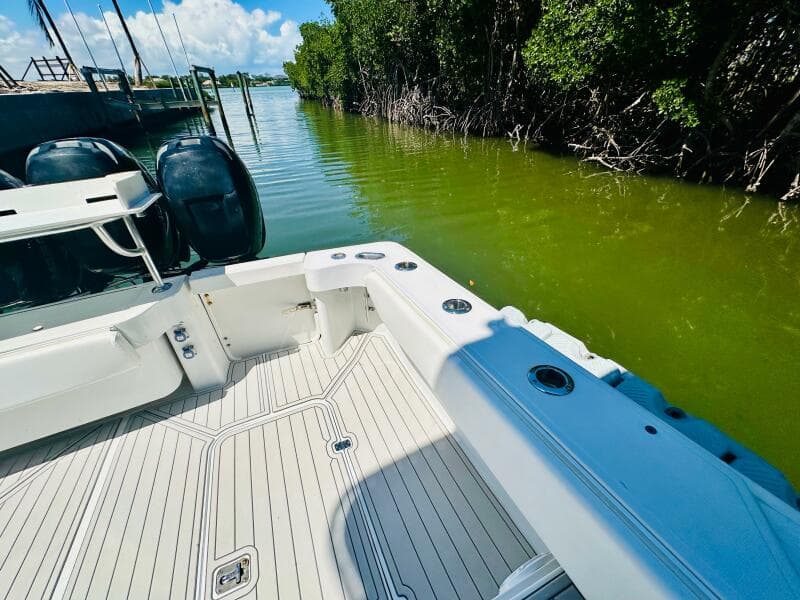 2000 Luhrs Tournament 320 Open boat docked in a serene, green waterway.
