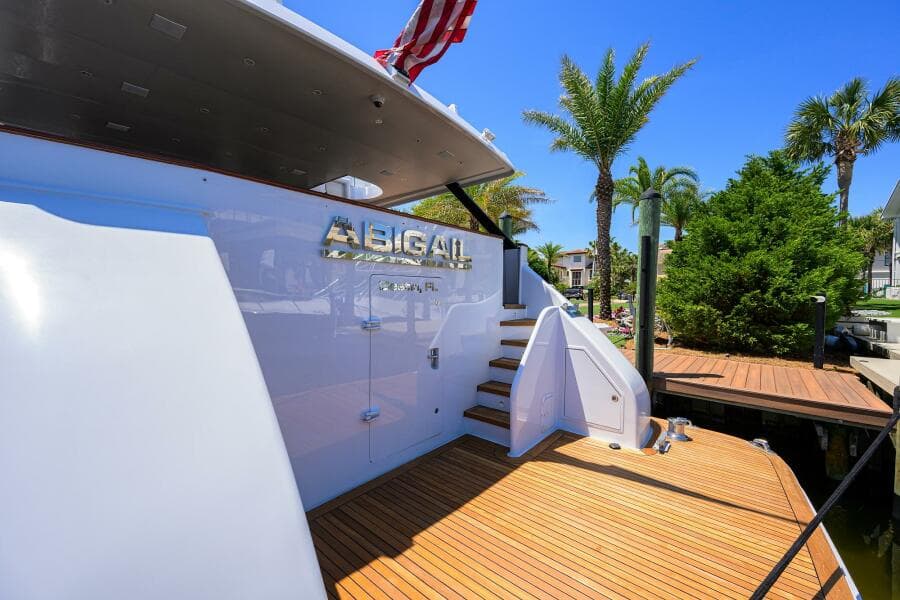 1997 Broward 108 Raised Pilothouse yacht docked with palm trees in the background.