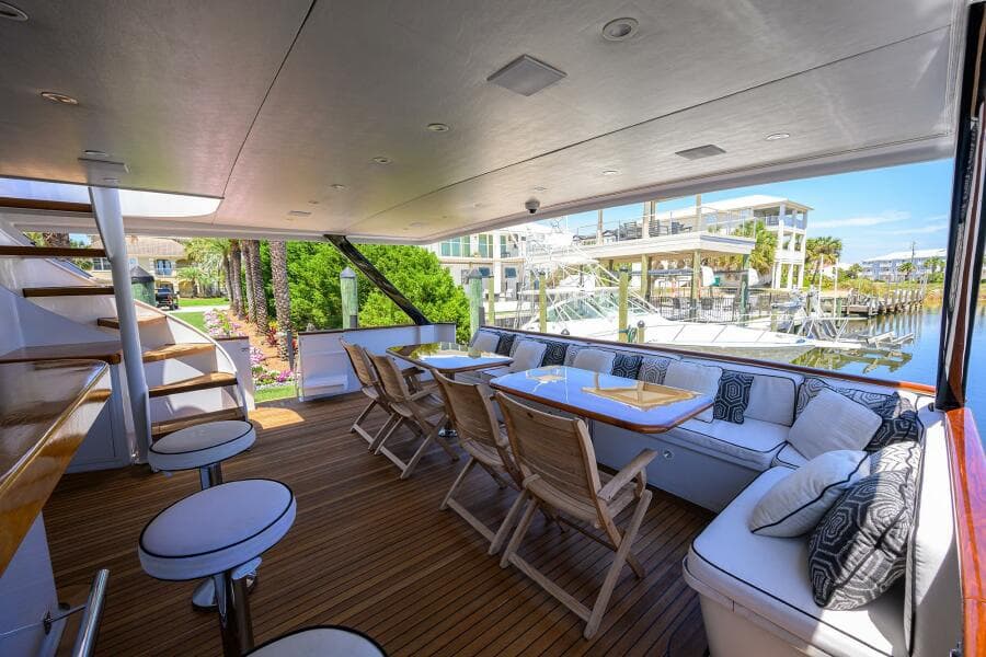 Spacious deck of 1997 Broward 108 Raised Pilothouse yacht with seating and dining area.