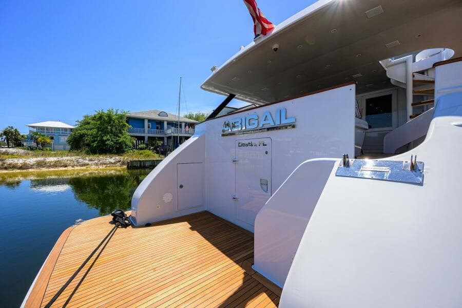 1997 Broward 108 Raised Pilothouse yacht docked, rear view with wooden deck.