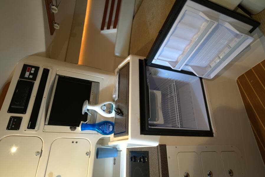 Interior of 2007 Grady-White Express 330 with open fridge and storage cabinets.