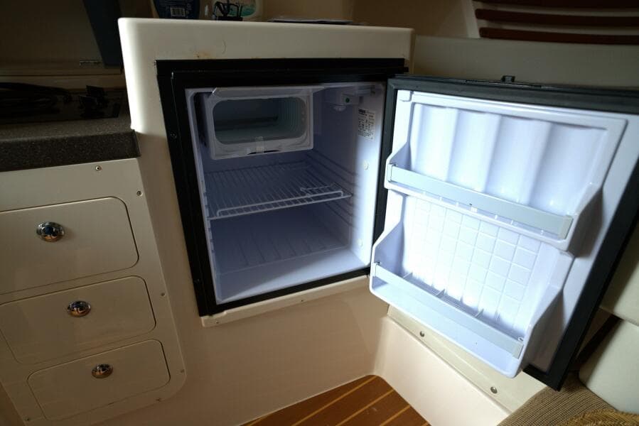 Open refrigerator inside 2007 Grady-White Express 330 boat cabin.