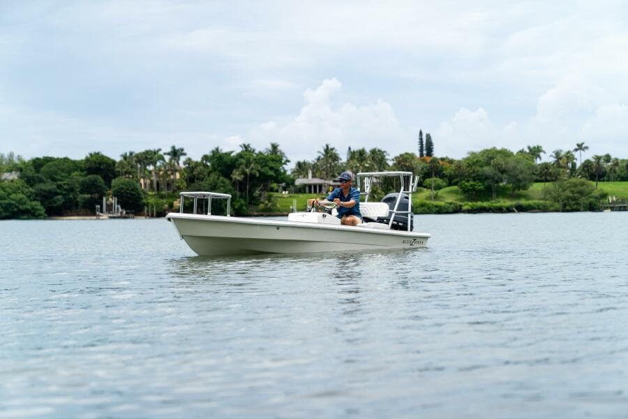 2025 BlueZones Boatworks 16' Flats on calm water, scenic background.