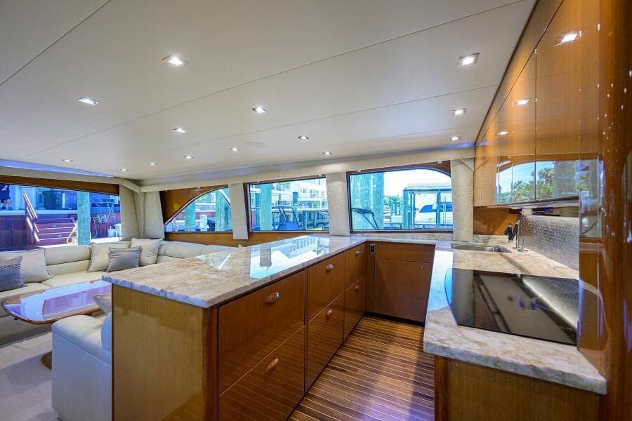 Luxurious interior of 2004 Viking 65 Enclosed Bridge yacht with modern kitchen and seating area.