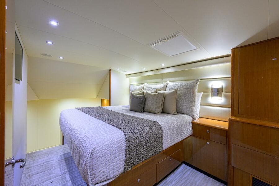 Luxurious bedroom interior of 2004 Viking 65 Enclosed Bridge yacht with modern lighting.