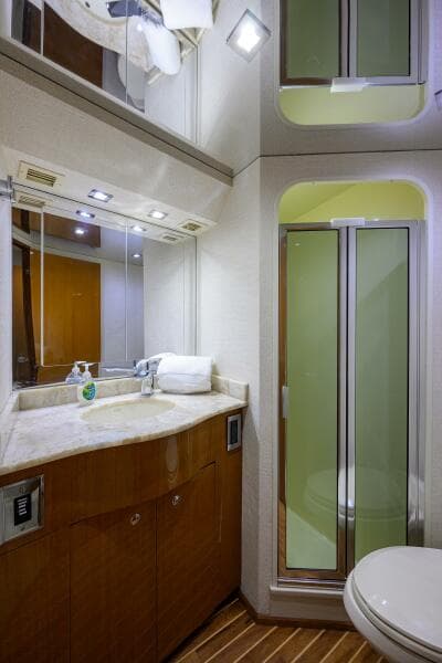 2004 Viking 65 Enclosed Bridge yacht bathroom with shower, vanity, and mirror.