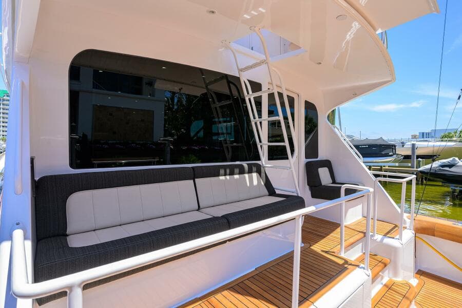 2004 Viking 65 Enclosed Bridge yacht with tower, featuring spacious outdoor seating and ladder access.