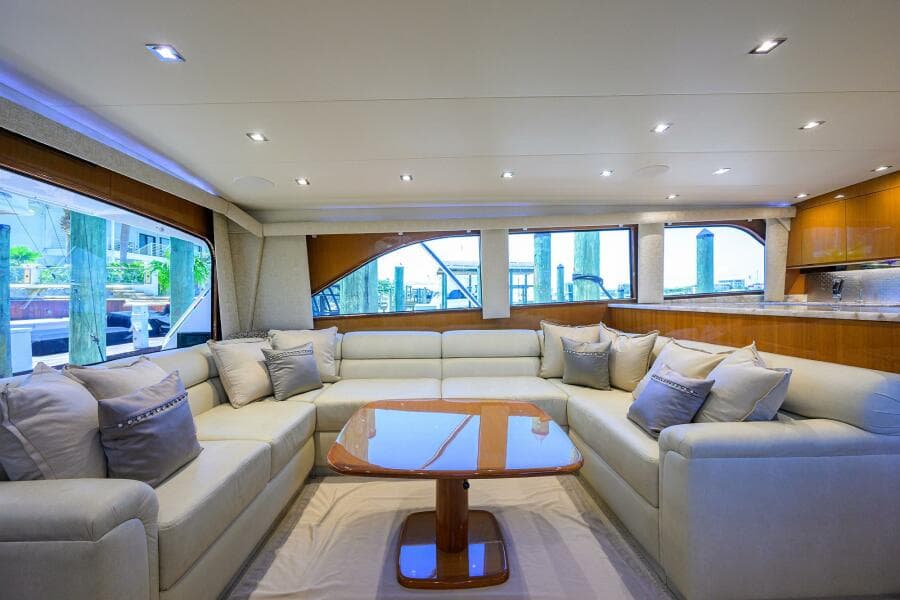 Luxurious interior of 2004 Viking 65 Enclosed Bridge yacht with plush seating and wooden table.