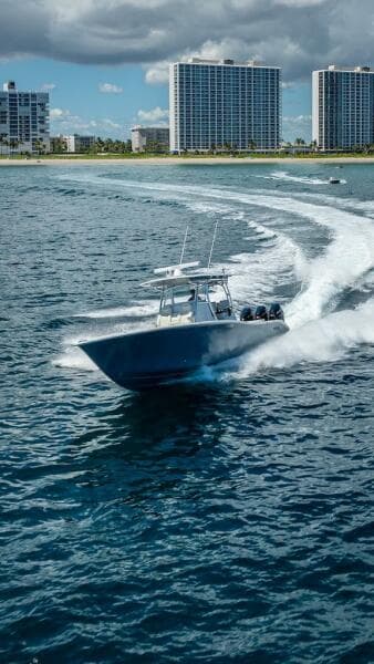 2025 Billfish 39 Center Console boat cruising near coastal skyscrapers.