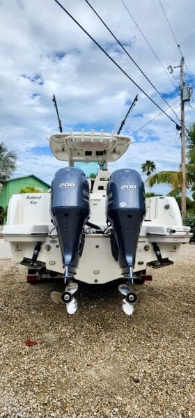 2021 Sailfish 272 CC boat with dual outboard engines, parked on gravel.