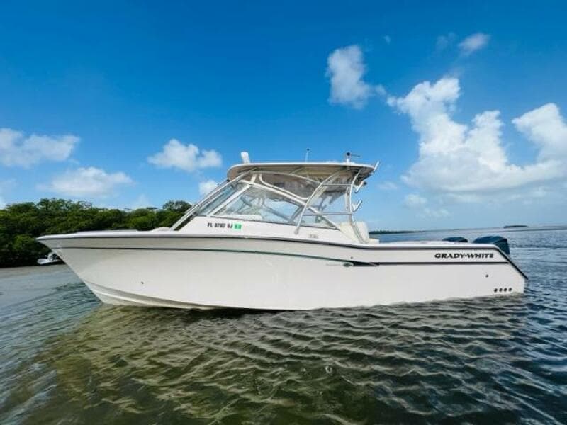2014 Grady-White Freedom 335 boat on calm water under a clear blue sky.