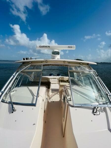 2014 Grady-White Freedom 335 boat on calm water under a clear blue sky.