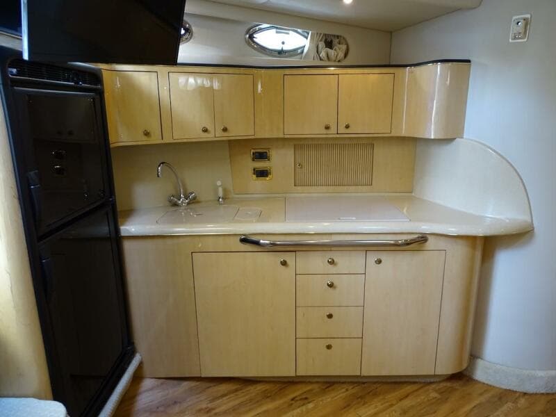 2001 Sea Ray 410 Sundancer yacht kitchen with wooden cabinets and modern appliances.