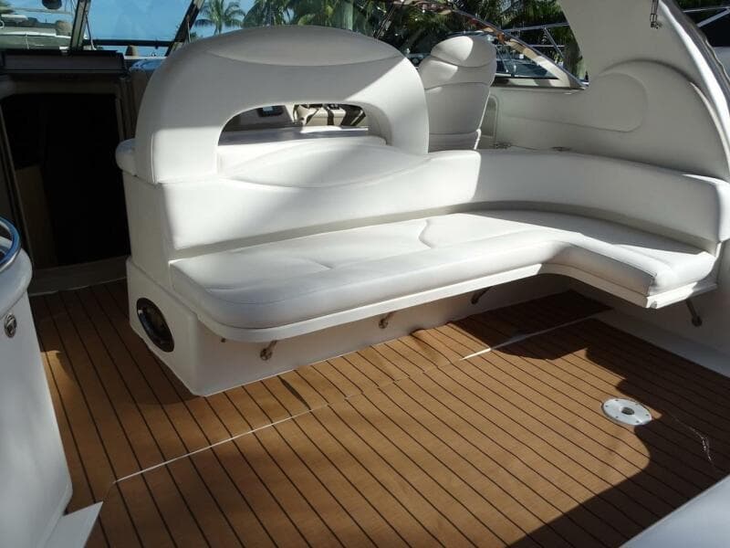 2001 Sea Ray 410 Sundancer boat interior with white seating and wooden flooring.