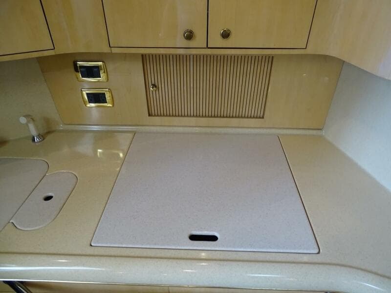 2001 Sea Ray 410 Sundancer kitchen countertop with sink and stove cover.