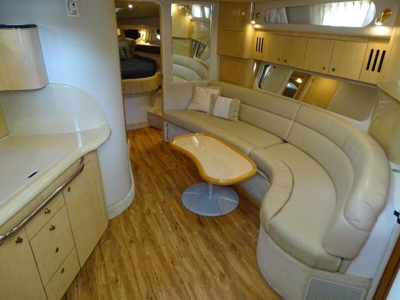 2001 Sea Ray 410 Sundancer interior with curved seating and wooden flooring.