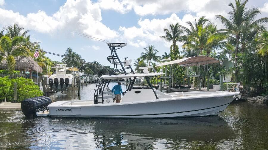 2020 Regulator 41 boat docked in a tropical marina with palm trees.