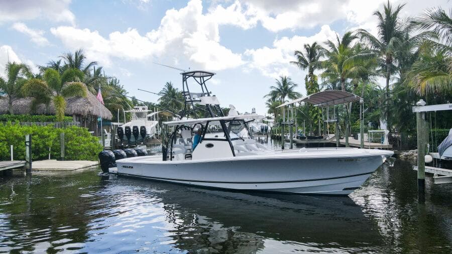 2020 Regulator 41 boat docked in a tropical marina with palm trees.