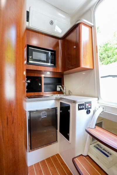 2020 Regulator 41 boat interior kitchen with microwave and wooden cabinetry.