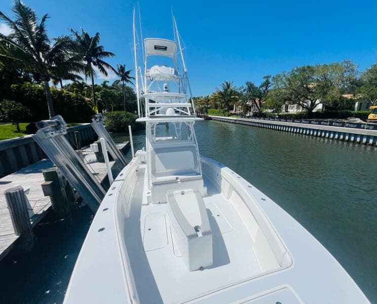 2015 Billfish 39 Custom CC boat docked by a canal on a sunny day.