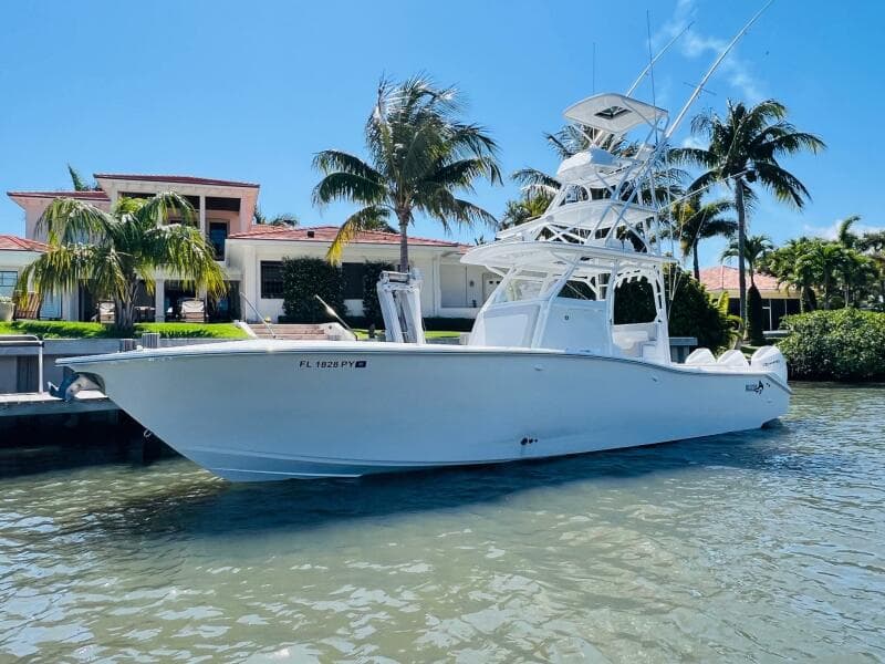 2015 Billfish 39 Custom CC boat docked near a waterfront home.