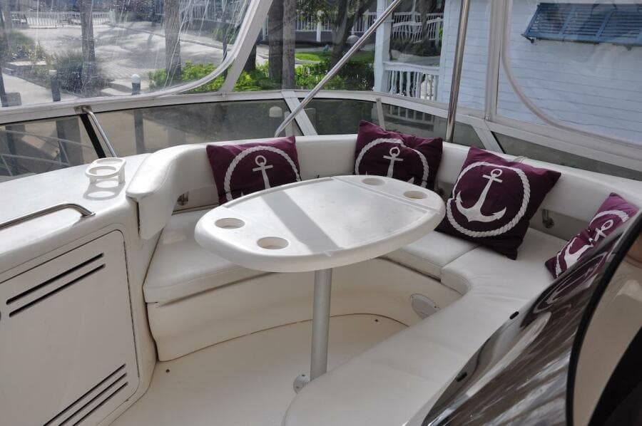 1998 Sea Ray 480 Sedan Bridge yacht interior with white seating and anchor-themed pillows.