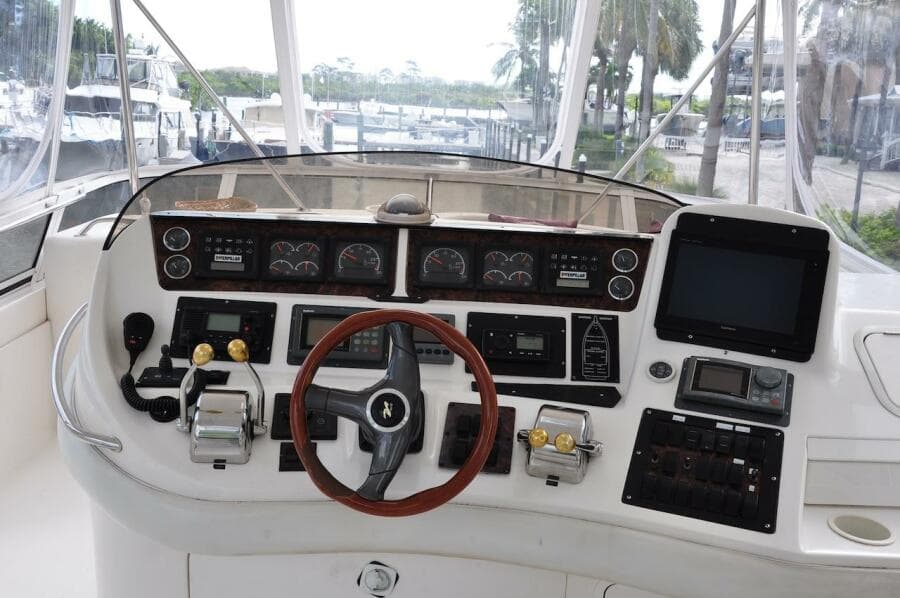 1998 Sea Ray 480 Sedan Bridge helm with steering wheel, controls, and navigation instruments.