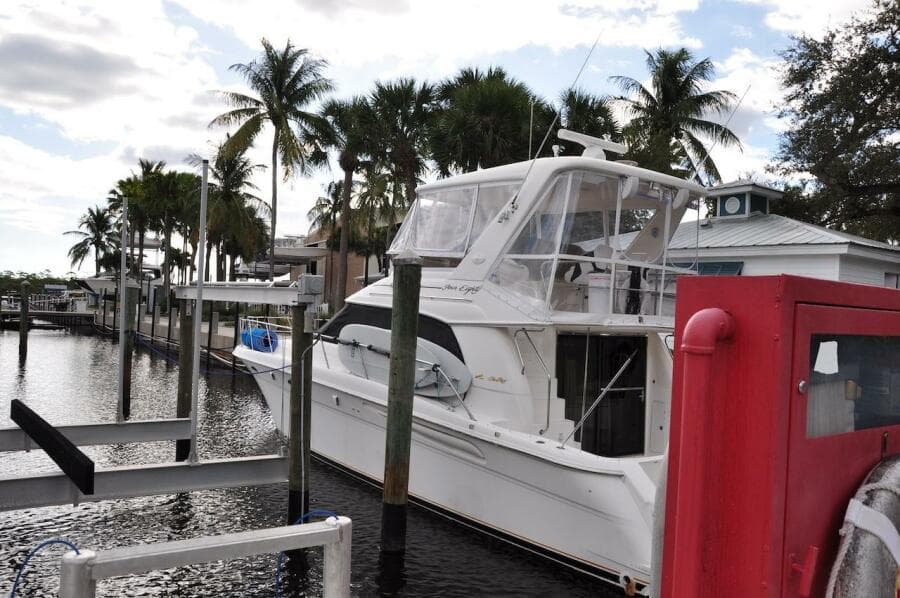 1998 Sea Ray 480 Sedan Bridge docked at a marina with palm trees.