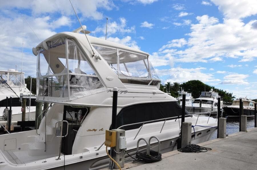 1998 Sea Ray 480 Sedan Bridge yacht docked at marina under blue sky.