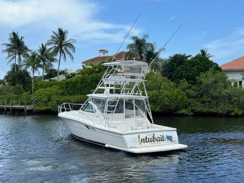 2003 Tiara Yachts 3800 Open cruising on a scenic waterway with lush greenery.