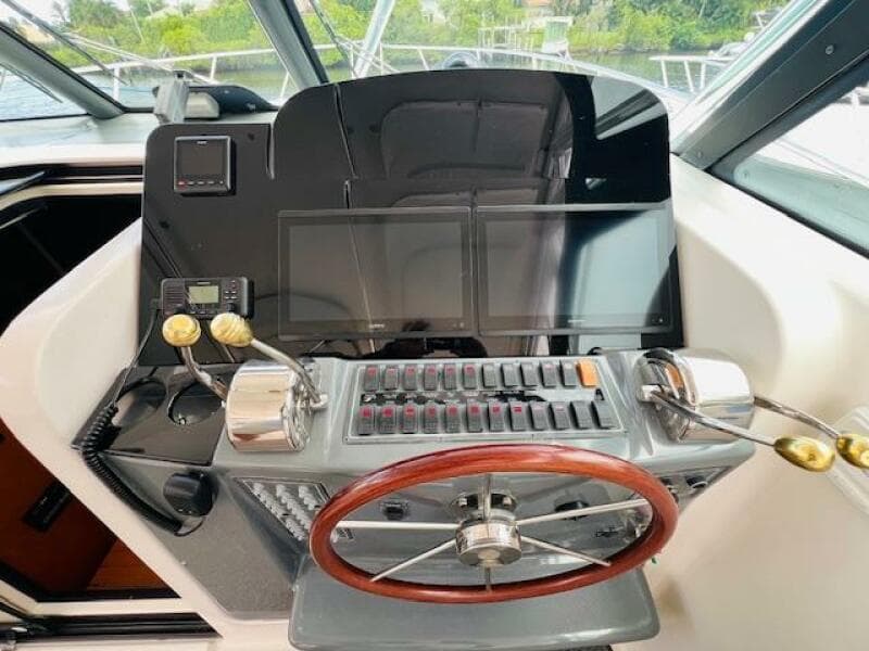 Tiara Yachts 3800 Open 2003 helm with wooden steering wheel and modern controls.