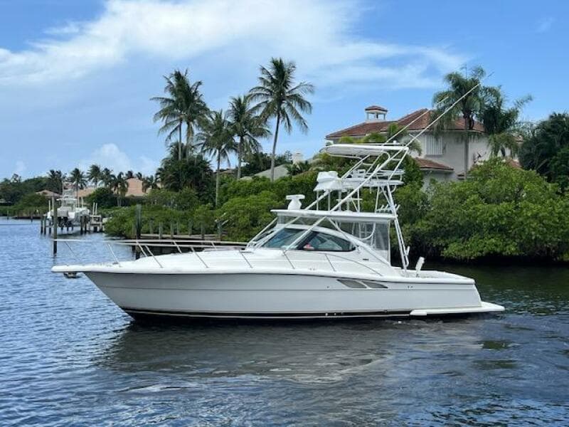 2003 Tiara Yachts 3800 Open cruising on a scenic waterway with palm trees.