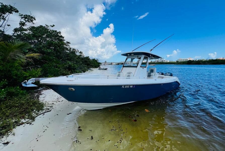 2012 Everglades 295 Center Console boat on sandy shore under blue sky.