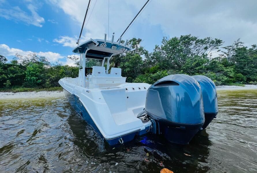 2012 Everglades 295 Center Console boat with dual engines in shallow water.