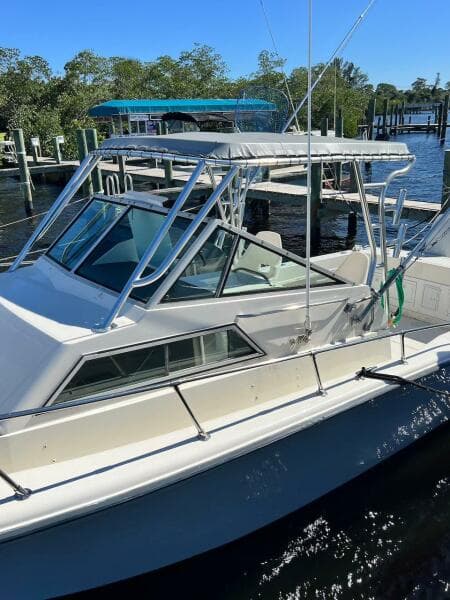 1988 Grady-White 25 SAILFISH boat docked in a marina, surrounded by water and trees.