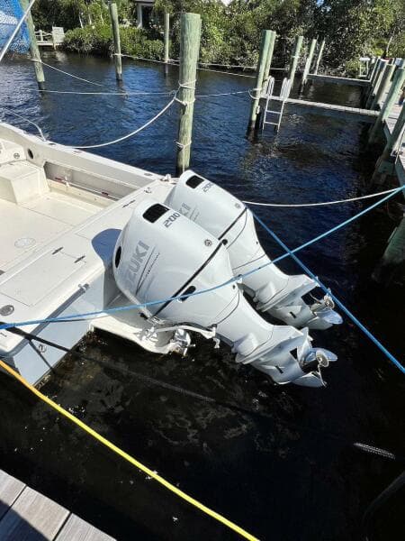 1988 Grady-White 25 Sailfish boat with dual outboard engines docked in marina.