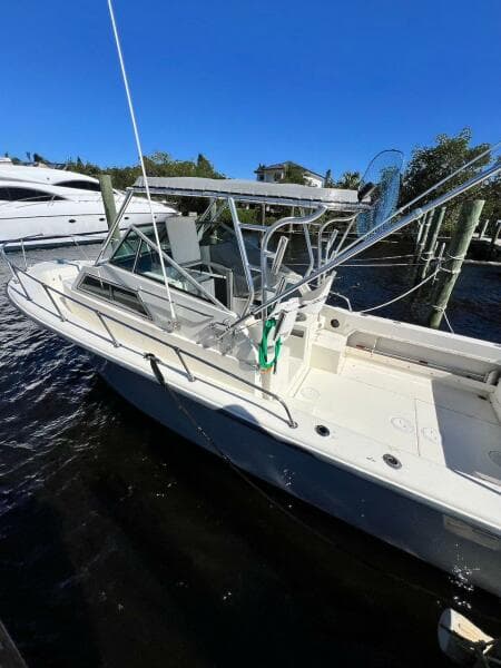 1988 Grady-White 25 SAILFISH boat docked under clear blue sky.