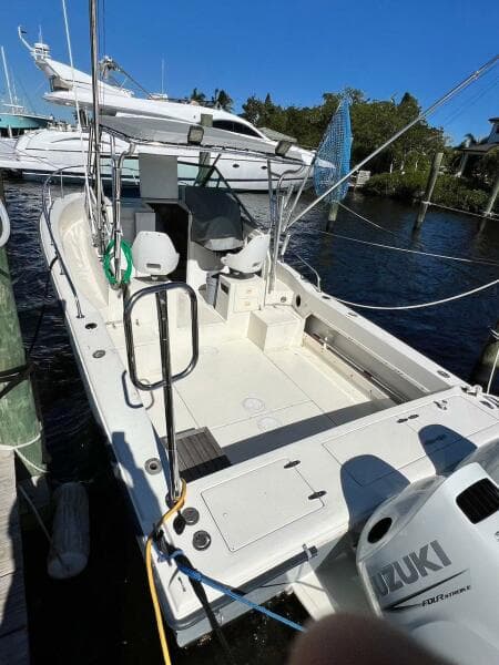 1988 Grady-White 25 SAILFISH boat docked with Suzuki outboard motor.