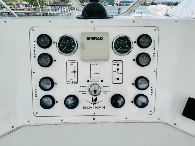 Control panel of a 1988 Bertram 54' yacht with gauges and Simrad equipment.
