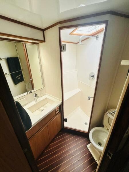 1988 Bertram 54' yacht bathroom with shower, sink, and toilet.