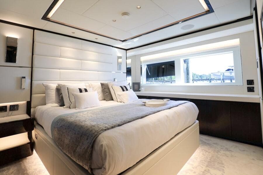 Luxurious bedroom interior on 2025 Majesty 120 yacht, featuring elegant design and large window.